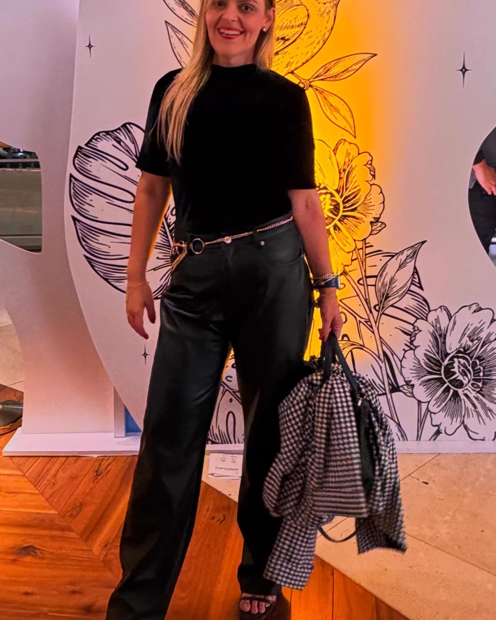 Amanda Brunetti num evento, junto a um cenário ilustrado